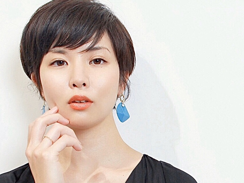 頬に手をあてるショートヘアの女性の写真