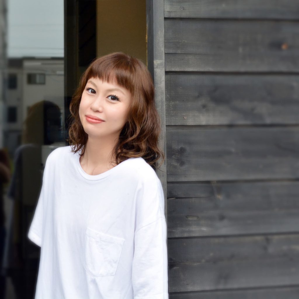 眉上バングのパーマヘアの女性の写真