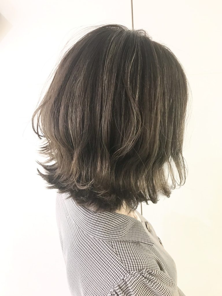 明るめアッシュベージュの細かいハイライトスタイルの女性の写真