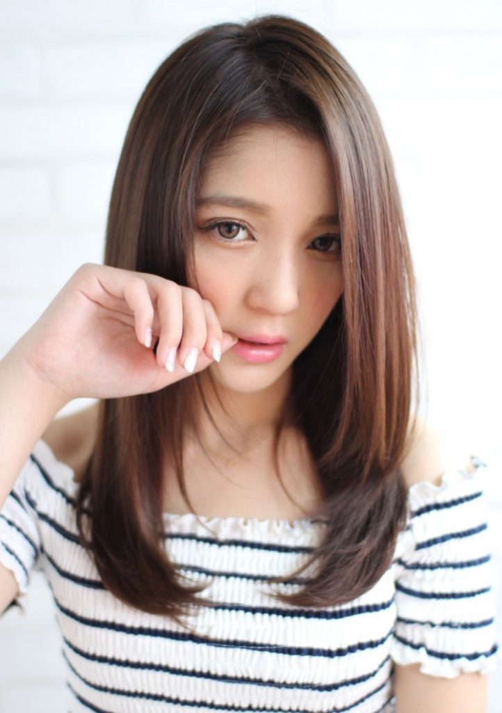 ツヤのあるブラウンカラーに染めたストレートヘアの女性の写真