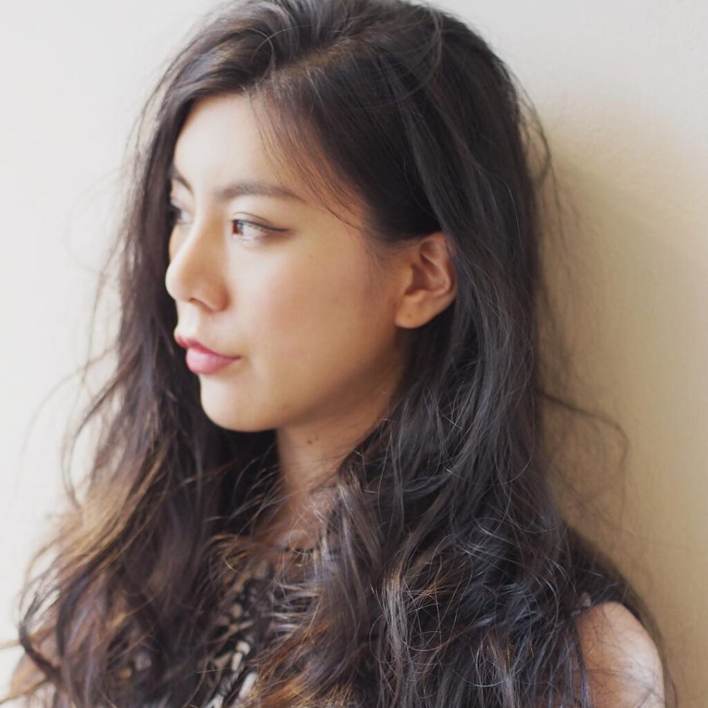 グラッドルームのパーマがかかったロングヘアの女性の写真