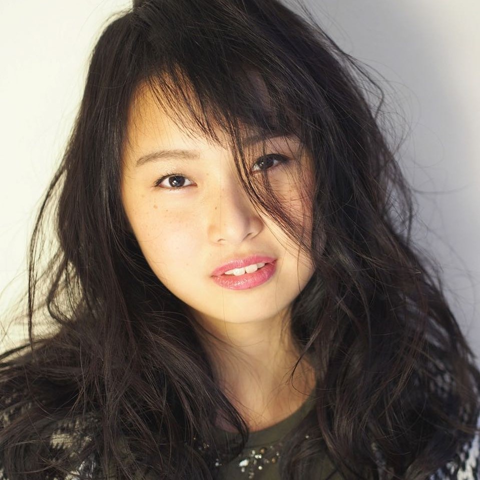 グラッドルームの正面を向いたロングヘアの女性の写真