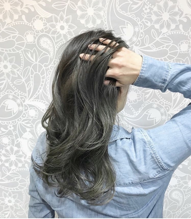 髪をかきあげる女性の写真