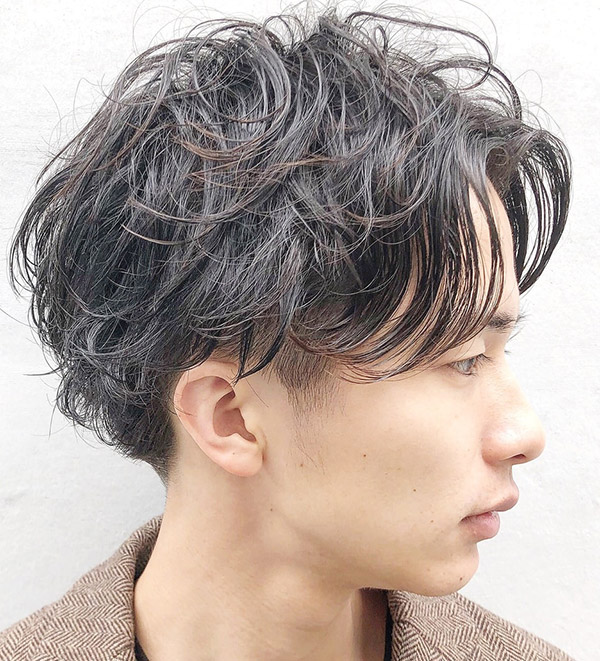 パーマをかけたツーブロックスタイルの男性の写真