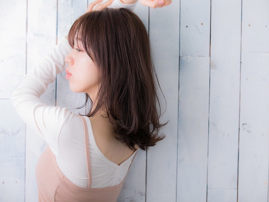 腕を上にあげた女性の後ろ姿の写真