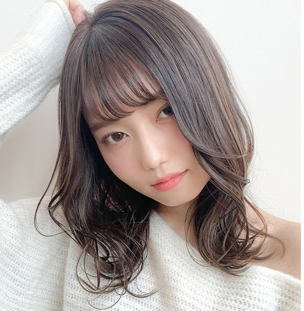 手を頭の上に添えた女性の写真