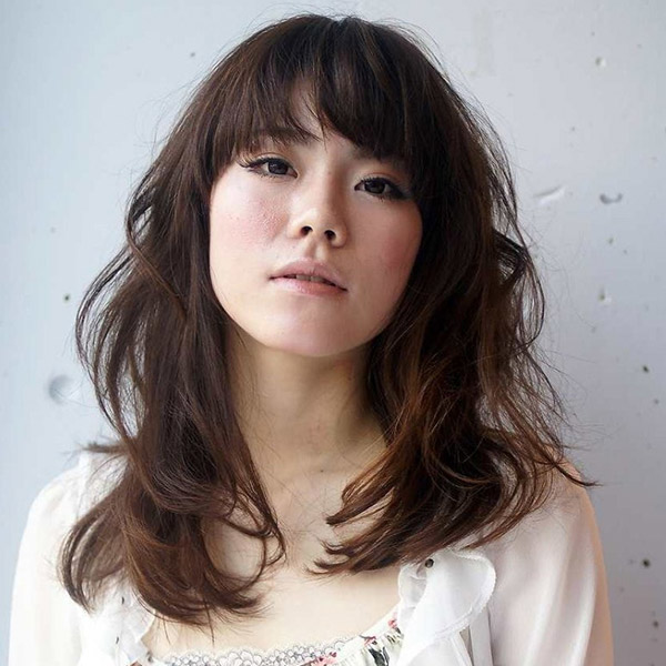 ゆるめのパーマをかけたロングヘアーの女性の写真