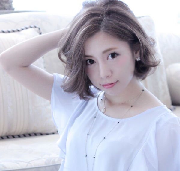 頭に手をのせたポーズの女性