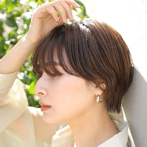 頭に手を添えた女性の写真
