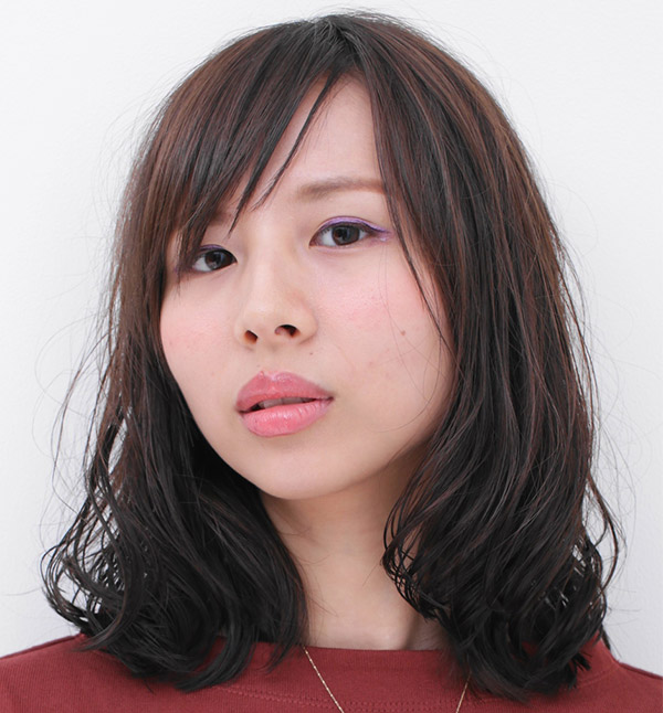 毛先にゆるいパーマのかかった女性の写真