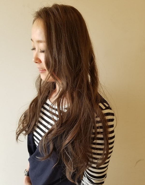 ウェーブロングスタイルの女性の横顔の写真