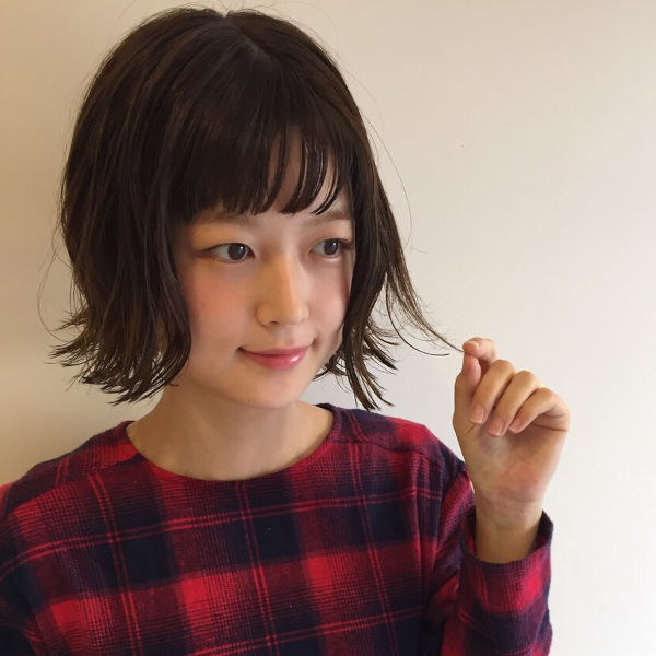 外はねの切りっぱなし風ボブスタイルの女性の写真