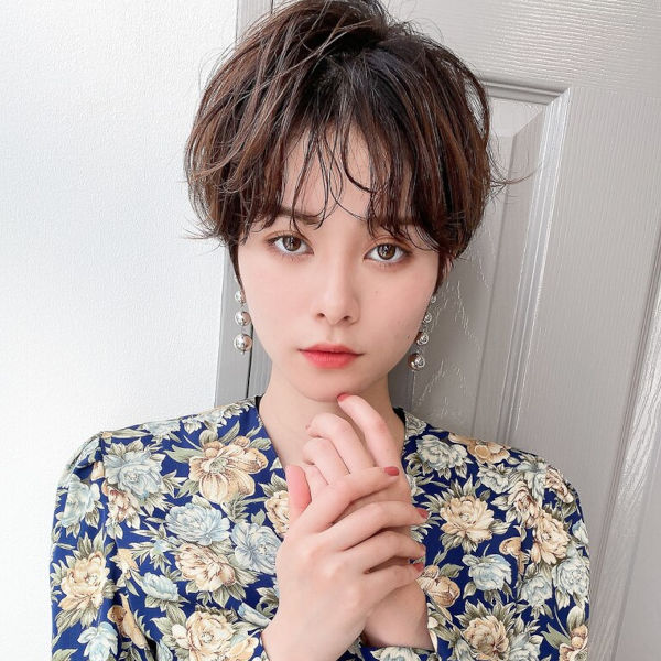 ナチュラルなパーマをかけたショートカットの女性の写真