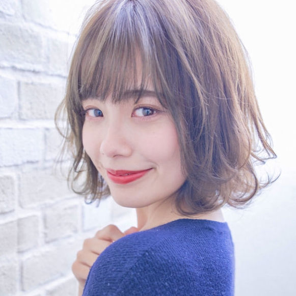 青い服を着たボブスタイルの女性