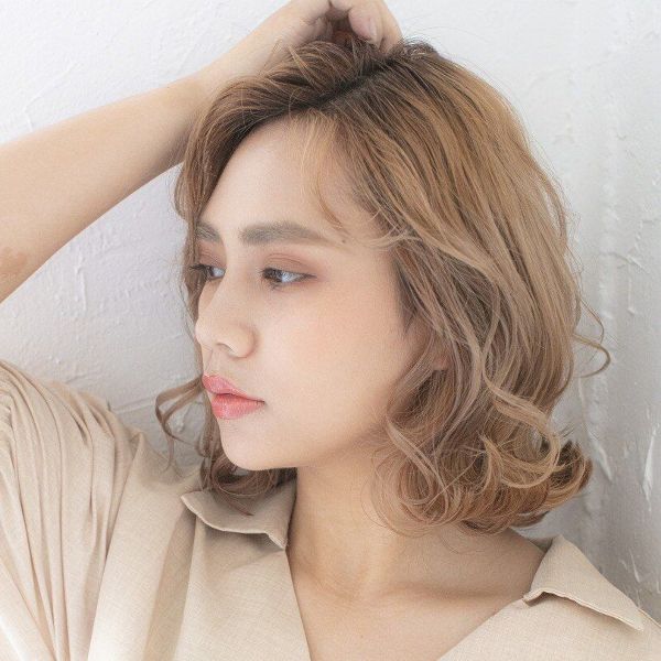 前髪をかき上げる女性の写真