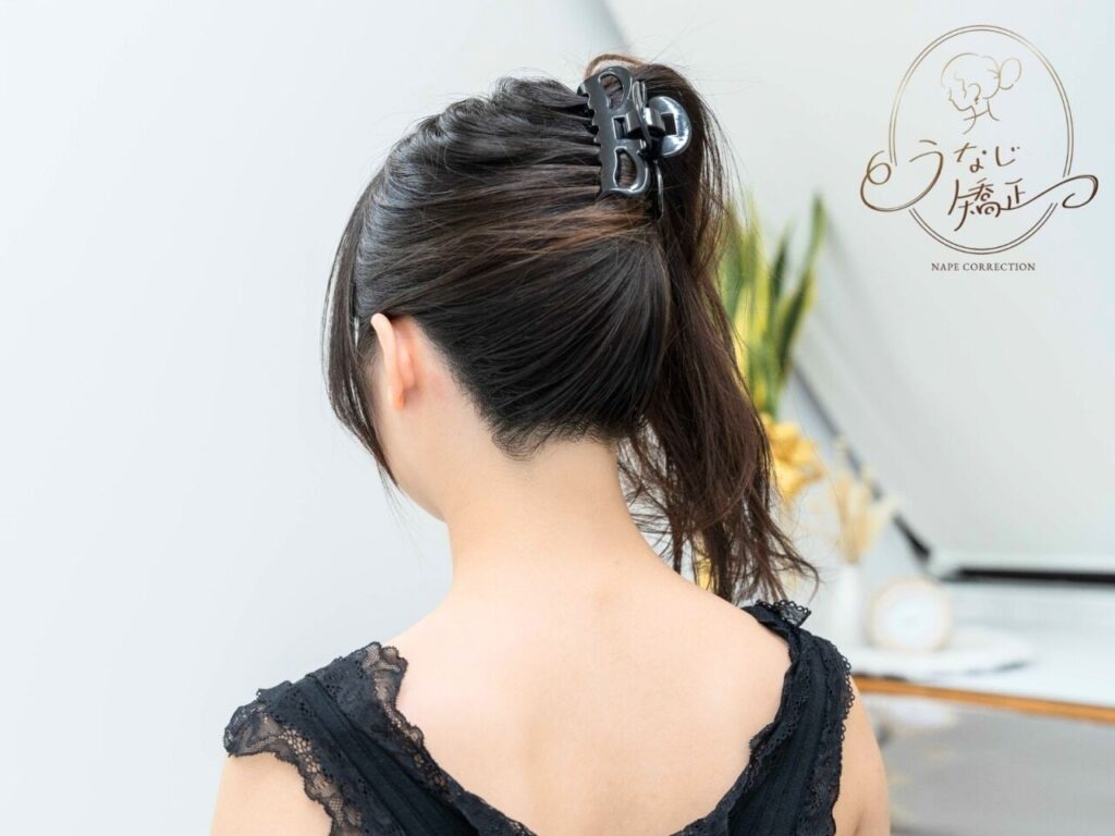 髪を黒の髪飾りでとめている女性のうなじの画像